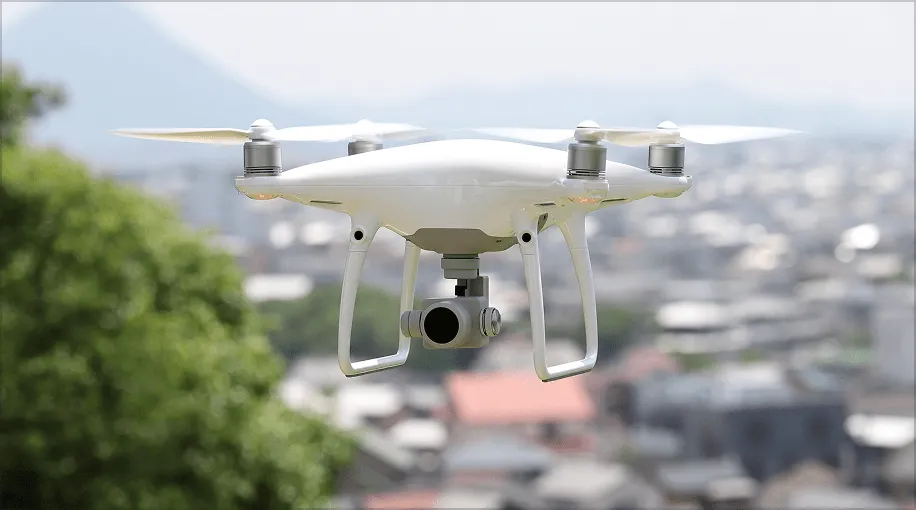 市街地の上空を飛行するドローンの写真。点検や撮影に活用できる様子。